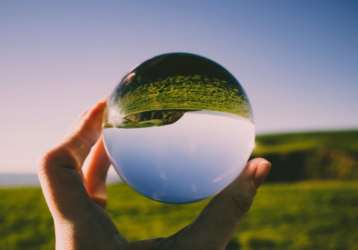 Image showing a person holding cristal ball and a mouintain reflection inside it