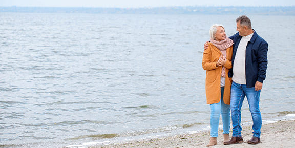 Old Couple Stolling Along the Beach: Maintaining Lifestyle in Retirement