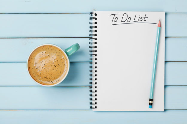 Coffee cup and notebook with to do list, savings guide and tax planning concept