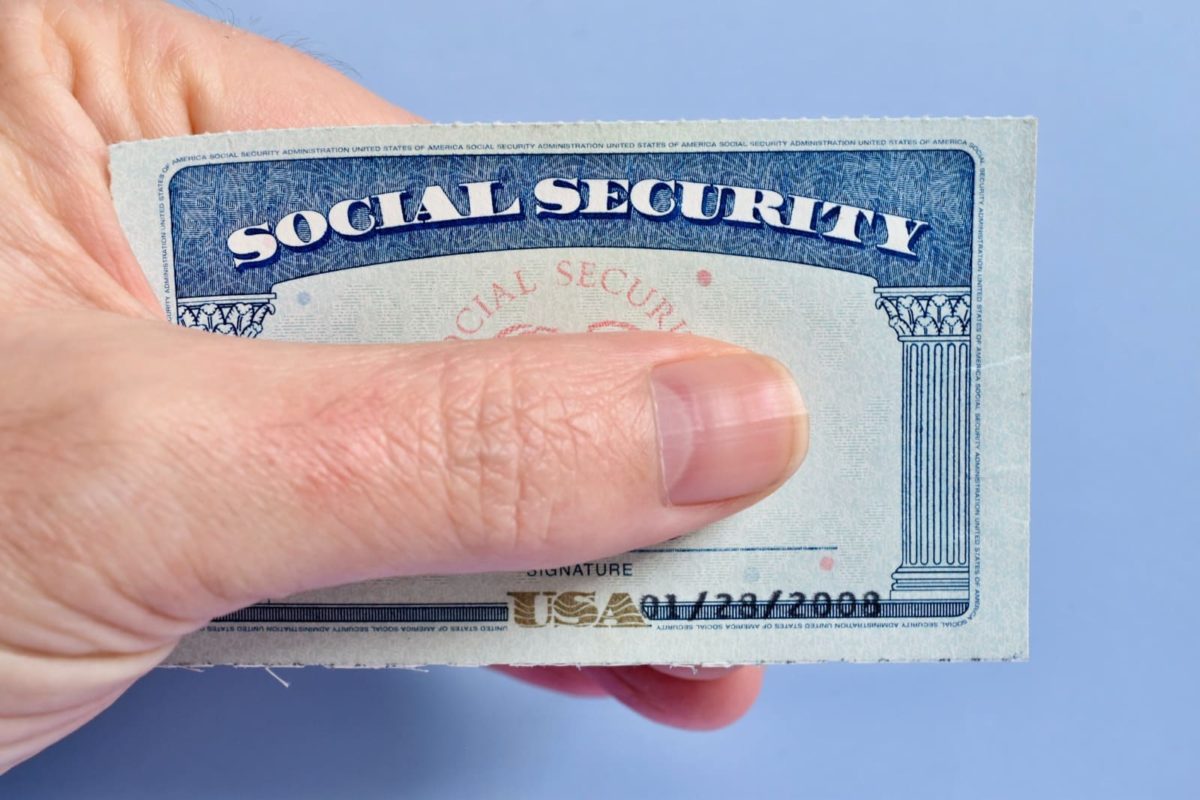 Social Security card held between fingers
